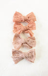 Set of three lace bow hair accessories on a white background