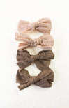 Set of three lace hair bows in pink and brown on a white background