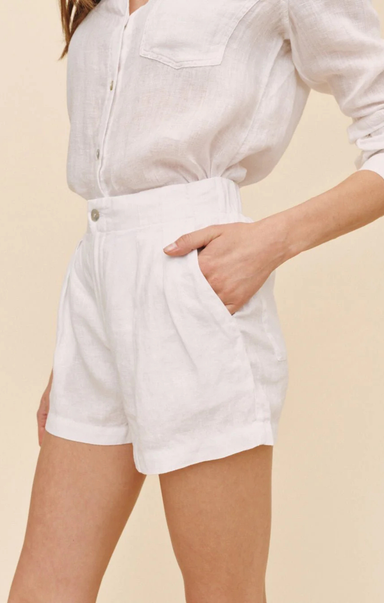 Person wearing white shorts and a light-colored shirt on a beige background