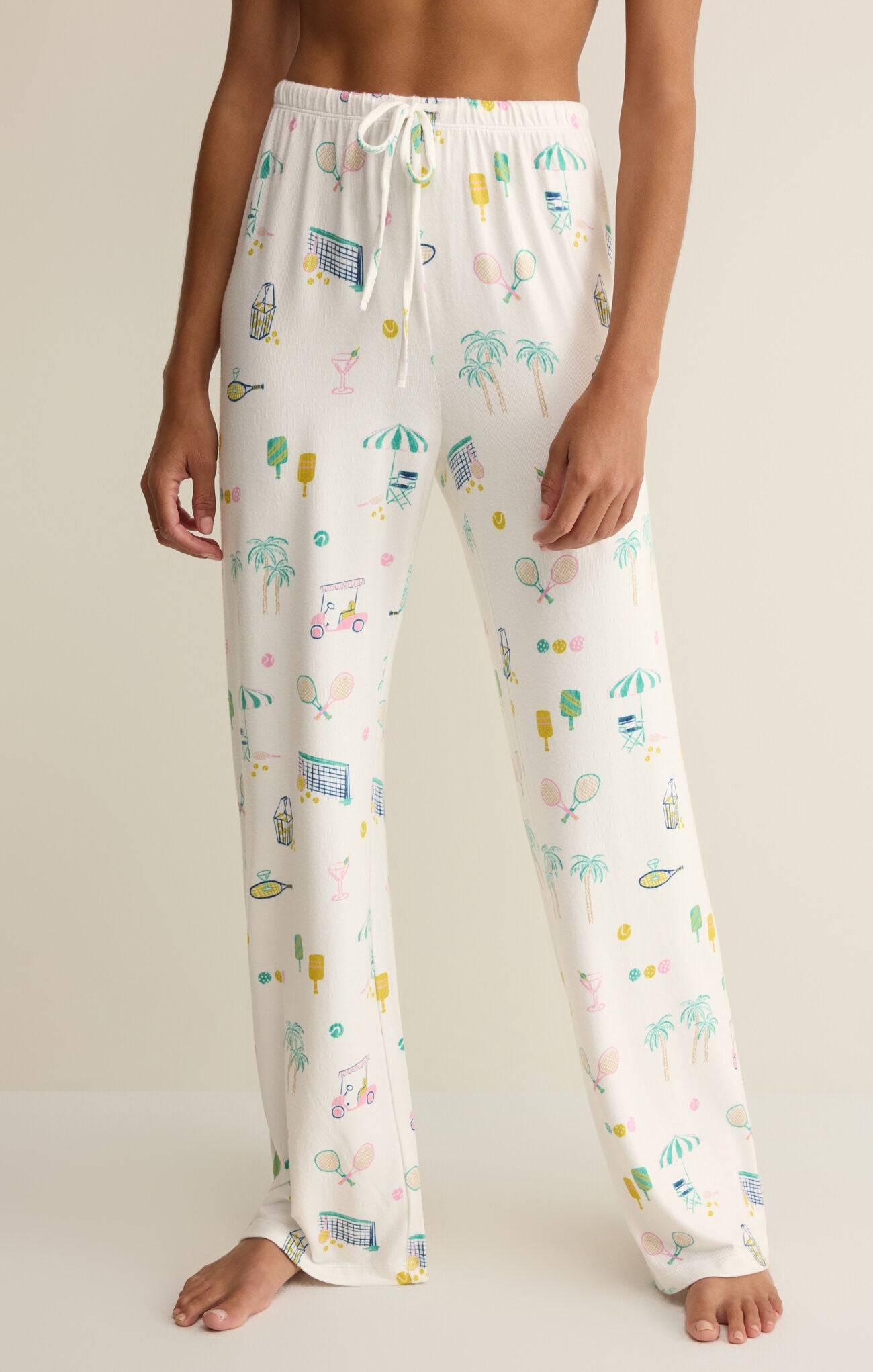 Person wearing a pair of pajama pants with a colorful pattern on a plain background