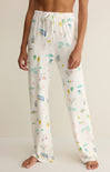 Person wearing a pair of pajama pants with a colorful pattern on a plain background