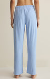 Light blue ribbed lounge pants worn by a person on a beige background