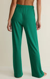Green pants worn by a person on a beige background