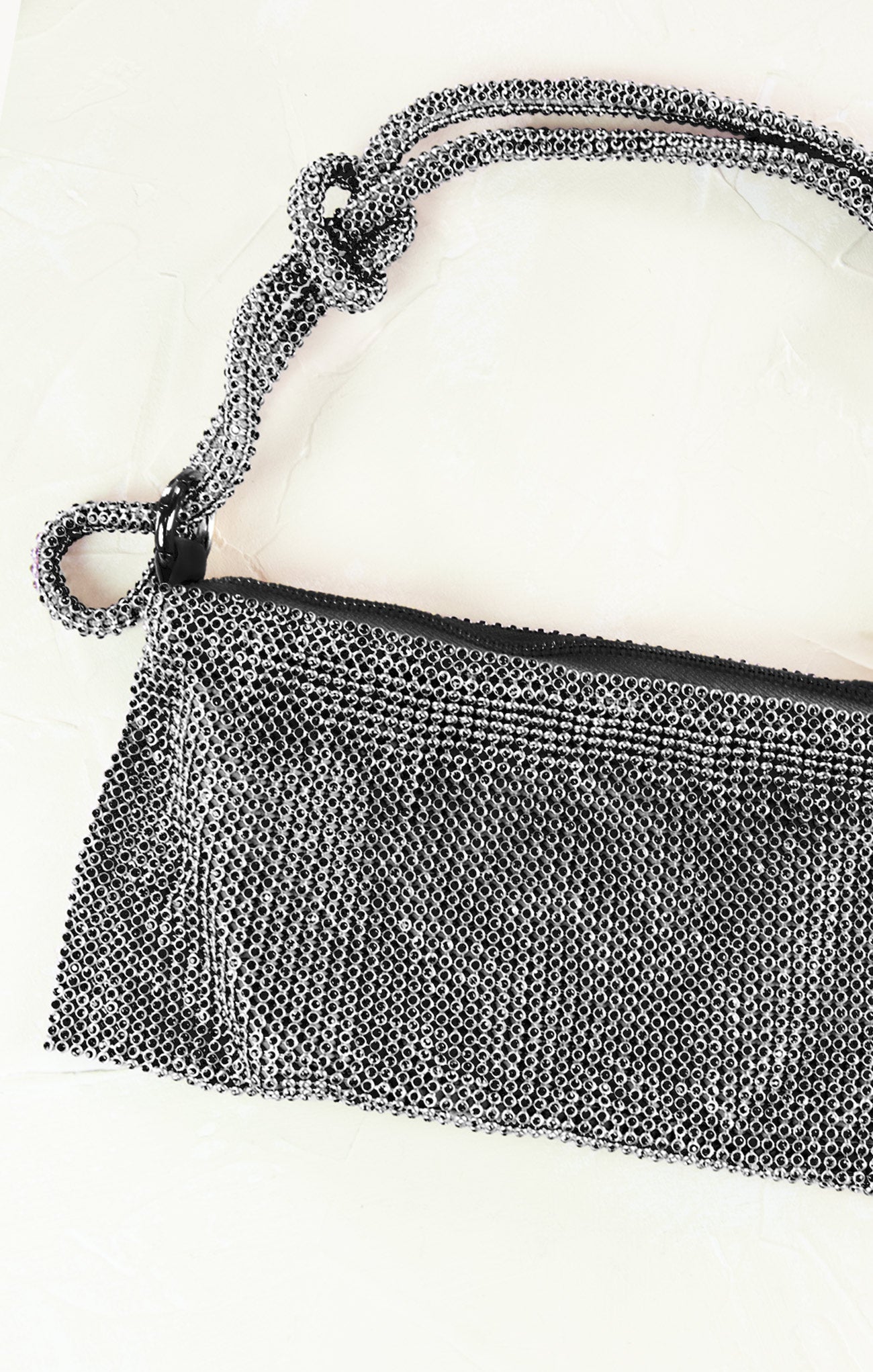 Close-up of a silver mesh handbag on a white background