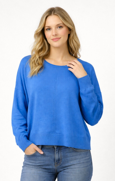 Woman wearing a blue sweater and jeans on a white background