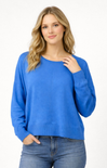 Woman wearing a blue sweater and jeans on a white background