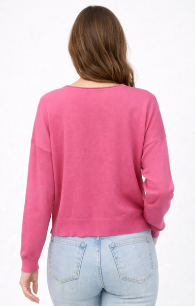 Person wearing a pink sweater and light blue jeans on a white background