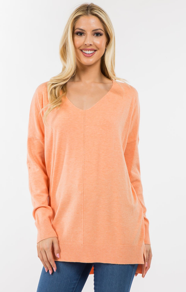 Woman wearing a peach-colored sweater on a white background