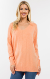 Woman wearing a peach-colored sweater on a white background