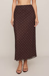 Brown polka dot skirt worn by a person on a beige background