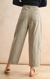 Person wearing plaid pants against a beige background