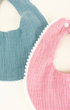 Two baby bibs, one pink and one blue, on a white background.