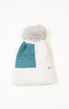 White knit beanie with a teal section and gray pom-pom on a white background