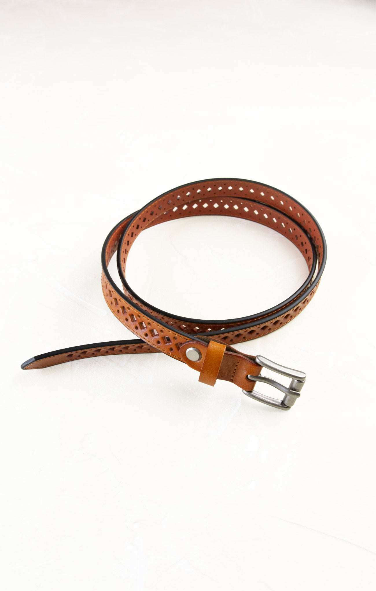 Brown leather belt with perforated design on a white background