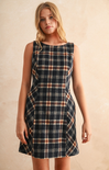 Woman wearing a plaid dress against a beige background