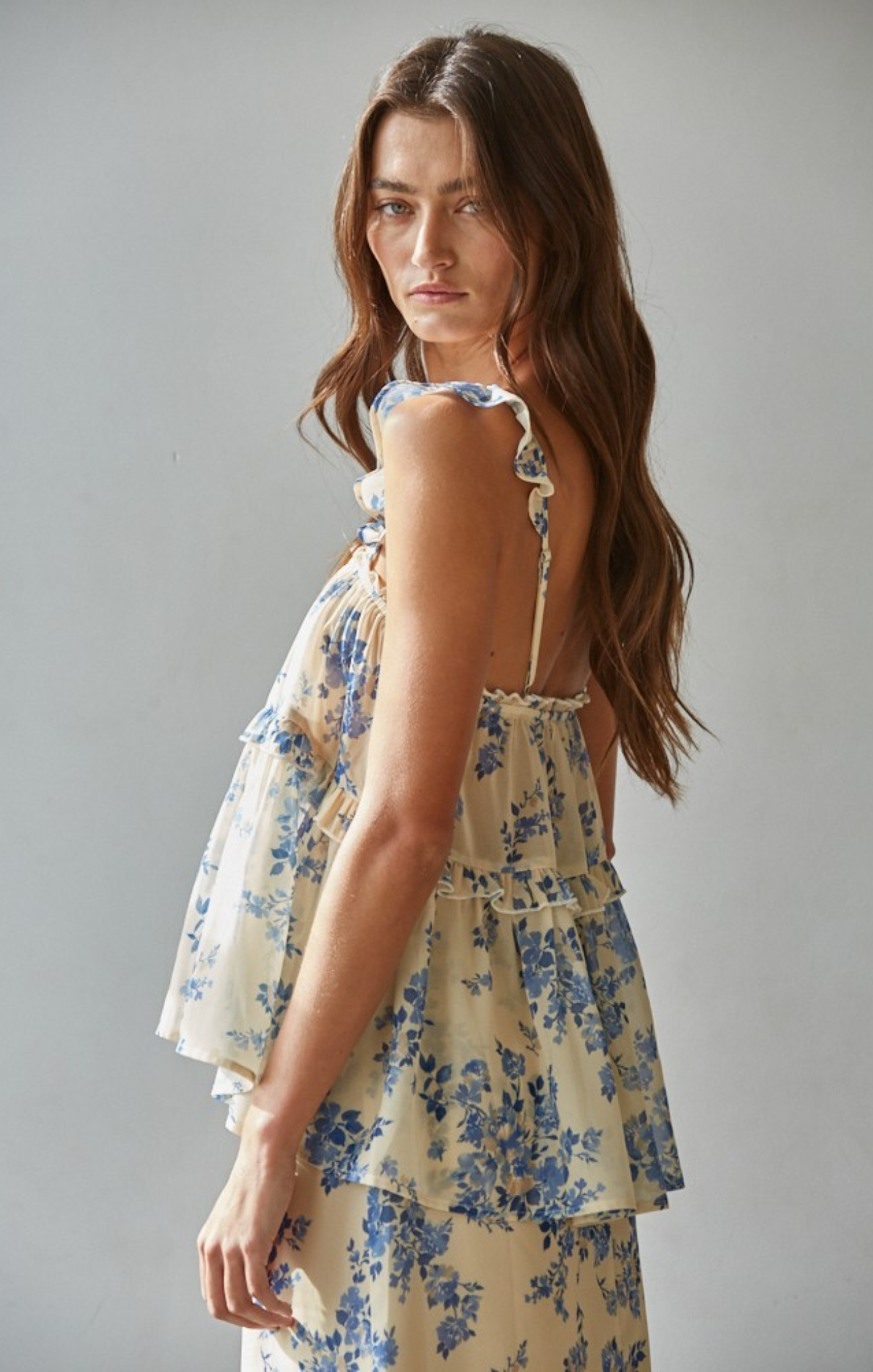 Woman wearing a floral dress against a plain background