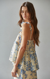 Woman wearing a floral dress against a plain background