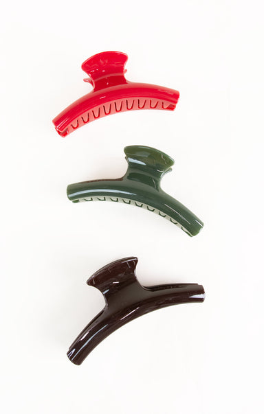Three hair clips in red, green, and brown on a white background