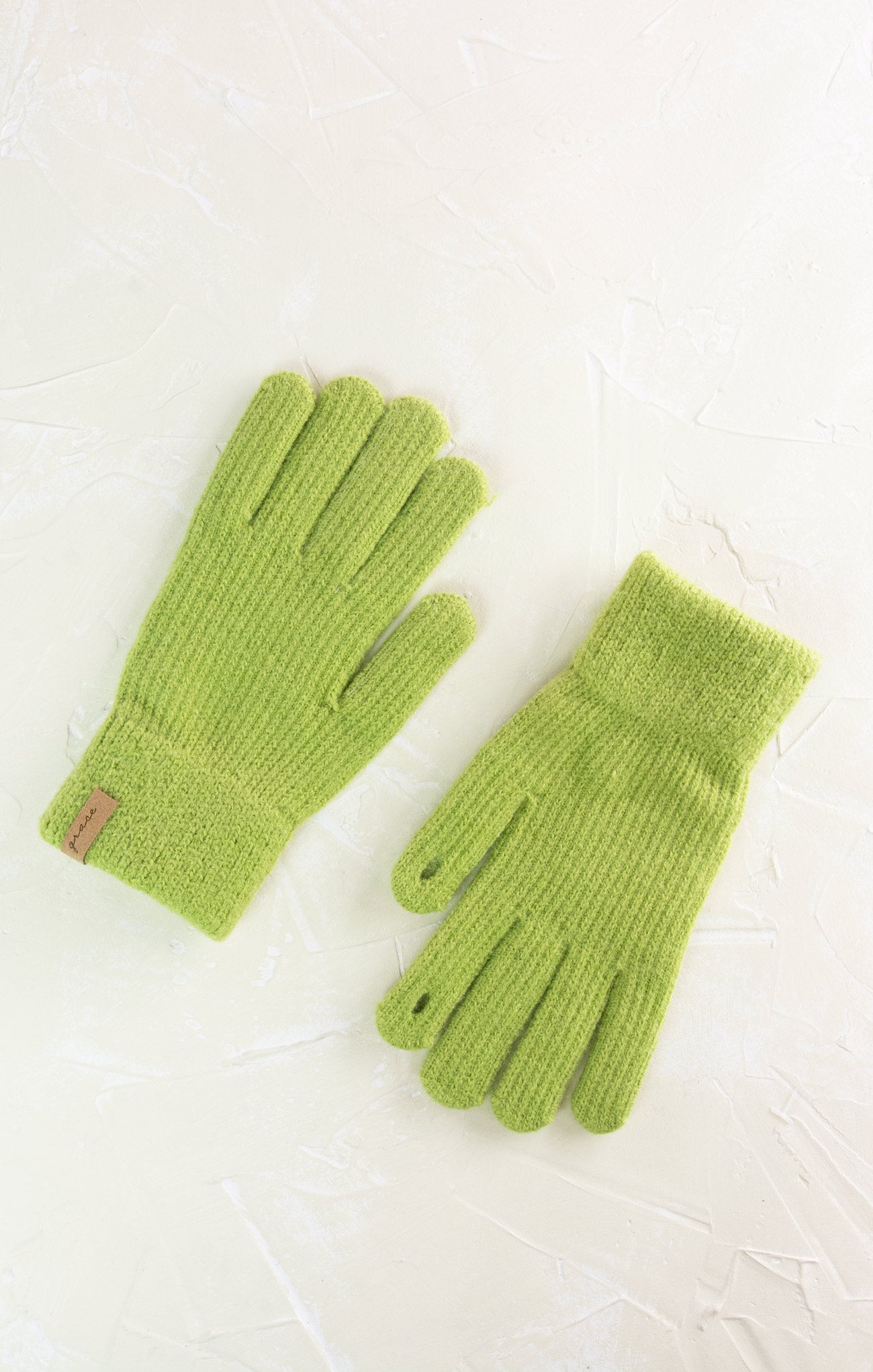 Pair of green gloves on a light background