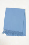 Light blue throw blanket with fringes on a white background
