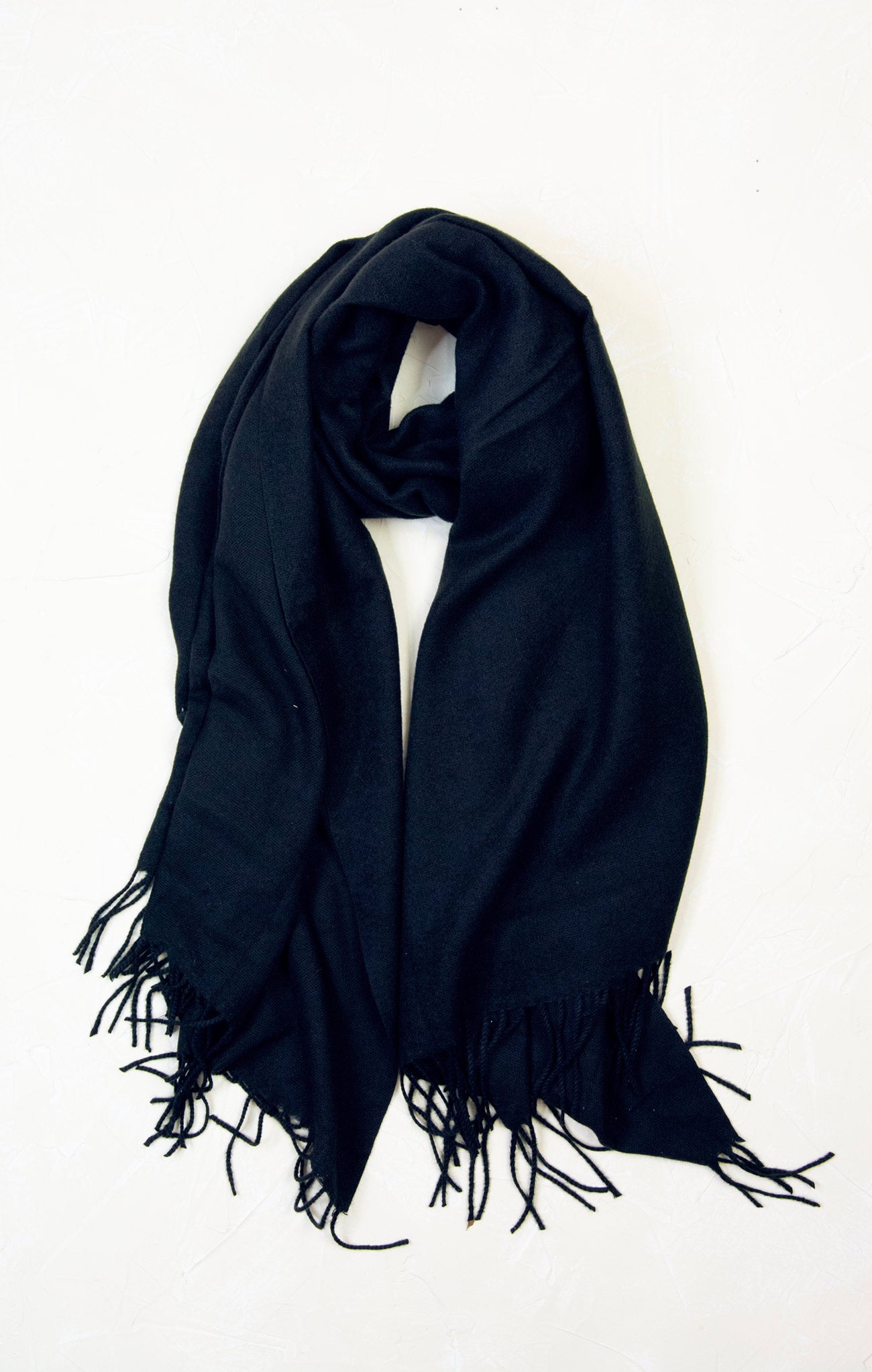 Black scarf with fringes on a white background