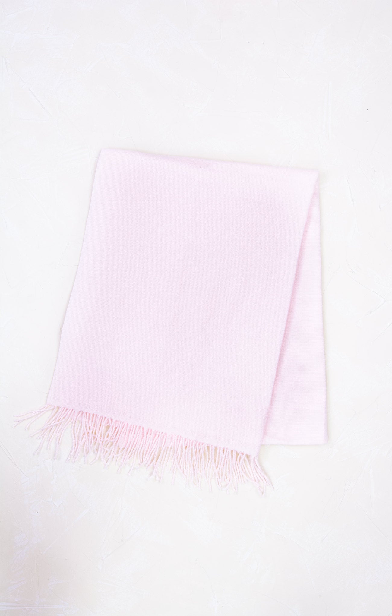 Light pink scarf with frayed edges on a white background