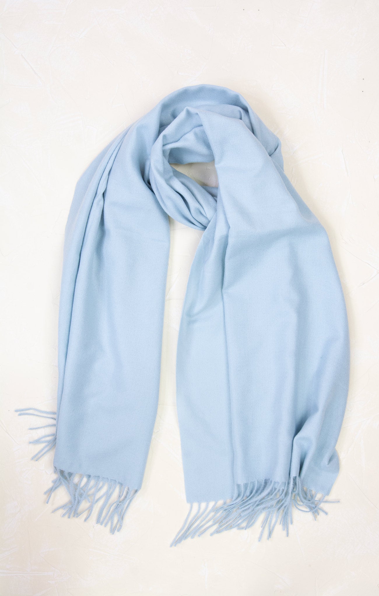 Light blue scarf with fringes on a white background