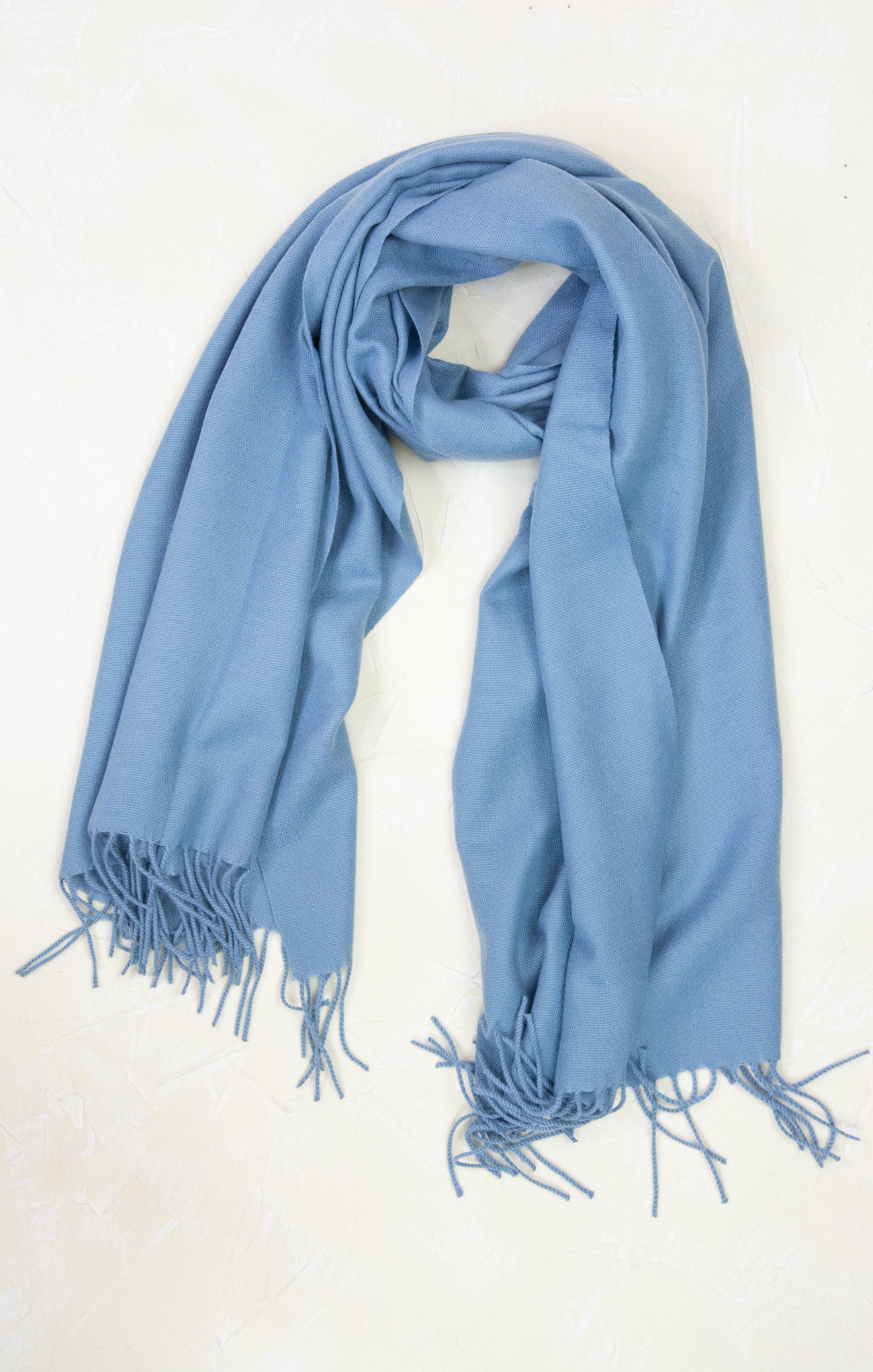 Light blue scarf with fringes on a white background