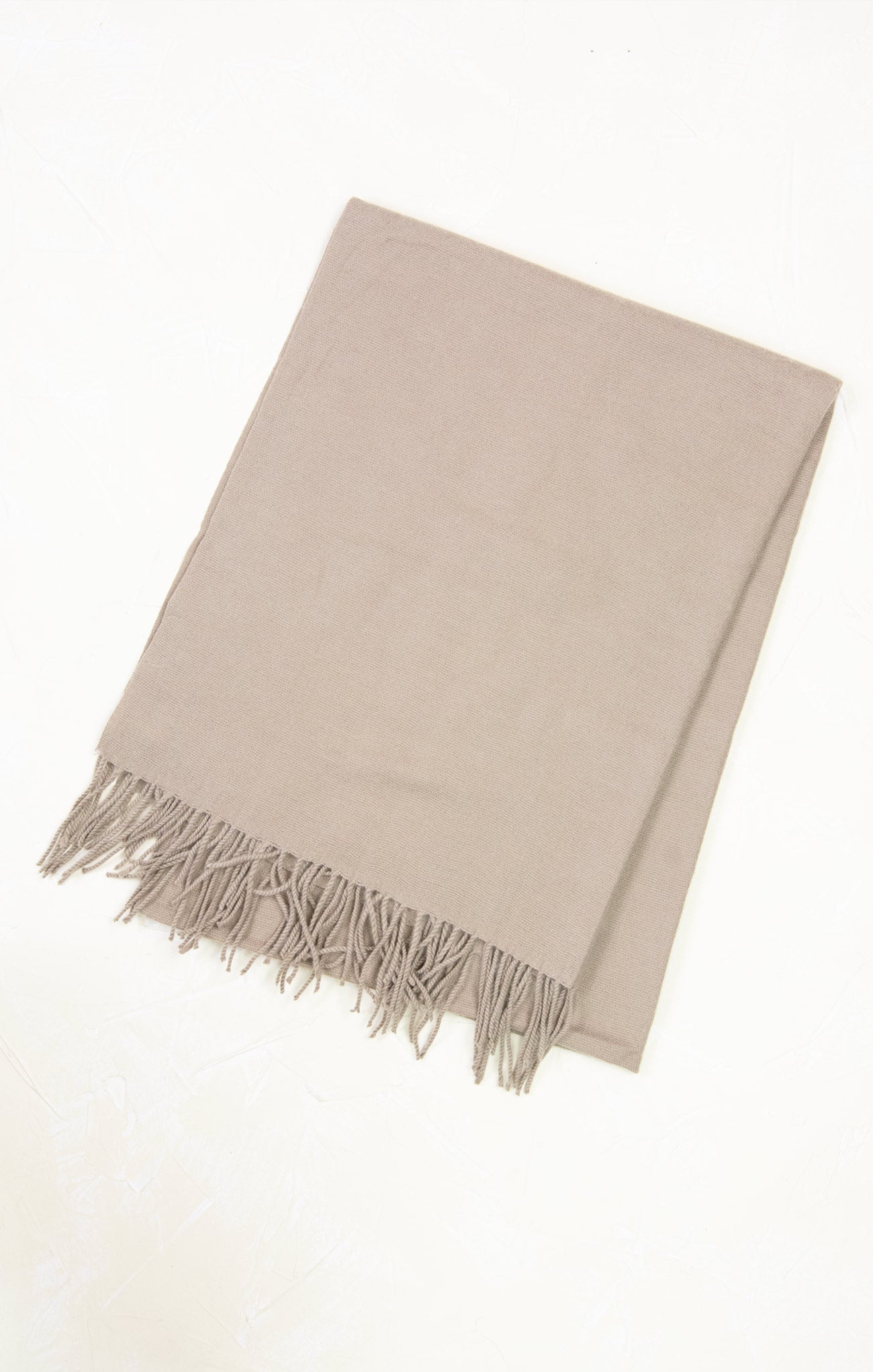 Beige blanket with fringes on a white background