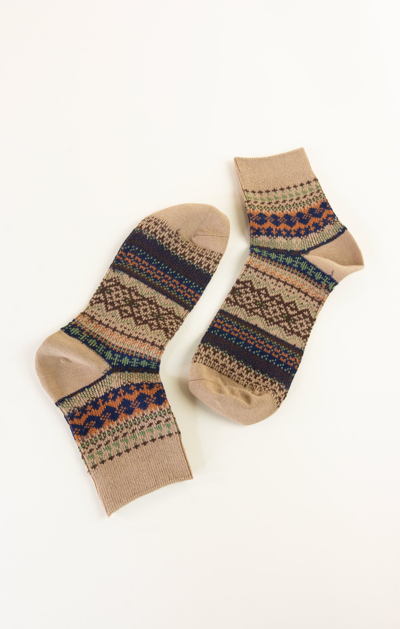 Pair of beige socks with patterned cuffs on a white background