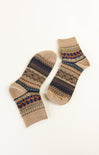 Pair of beige socks with patterned cuffs on a white background