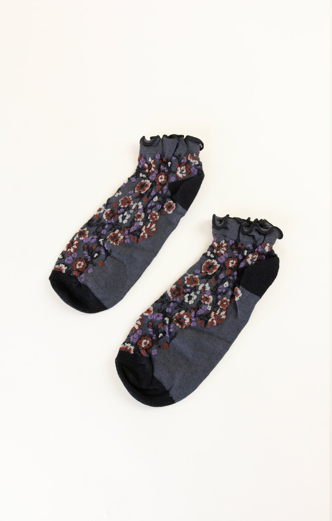 Pair of dark gray socks with floral patterns on a white background