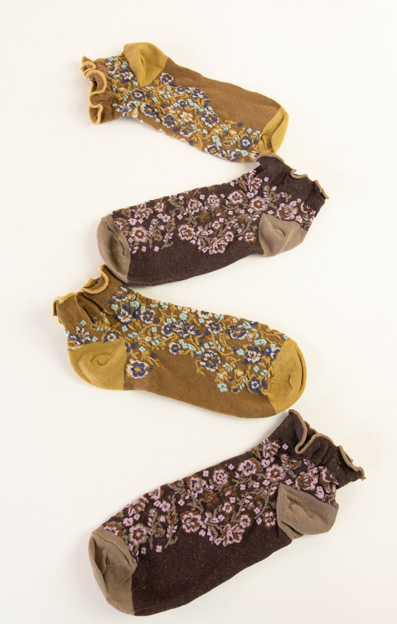 Two pairs of floral-patterned socks in brown and yellow on a white background