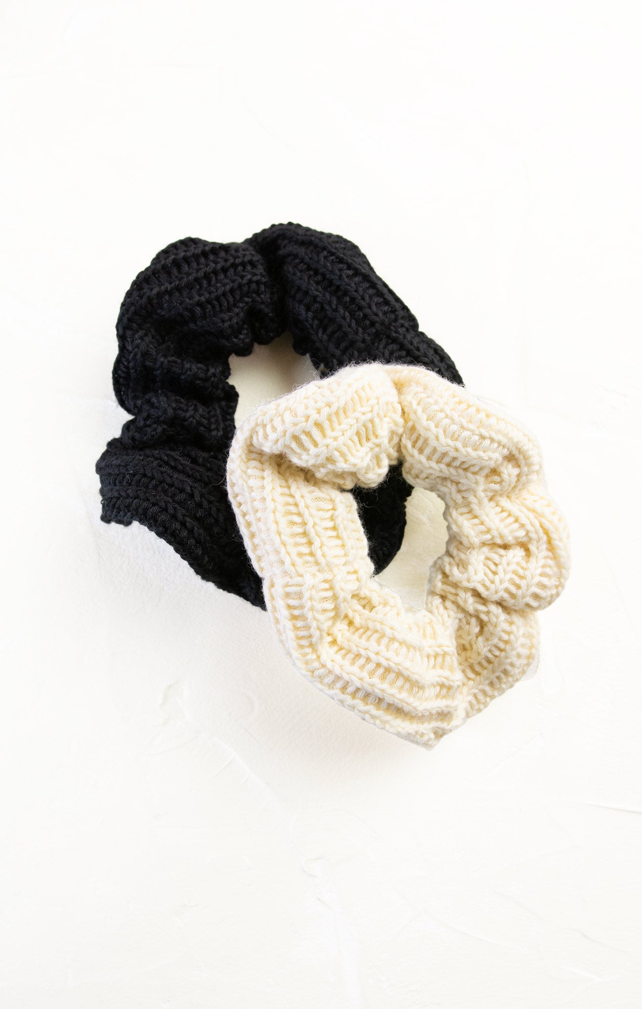 Black and white knitted scrunchies on a white background