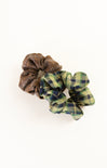 Two plaid scrunchies, one brown and one green and blue, on a white background.