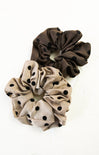 Two polka dot scrunchies, one brown and one beige, on a white background.