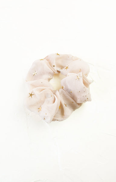 White scrunchie with gold stars on a white background