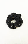 Black scrunchie with gold stars on a white background
