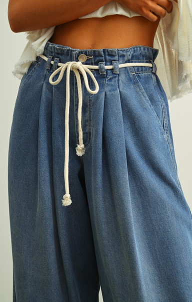 Blue wide-leg jeans with a drawstring waist on a plain background