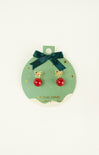 Pair of earrings with red balls and gold bows on a green card with a bow.