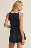 Woman wearing a navy blue sleeveless top and shorts set on a beige background