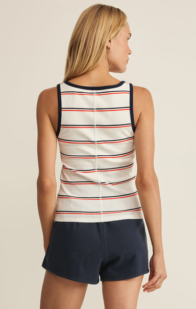 Woman wearing a striped tank top and navy shorts on a beige background