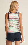 Woman wearing a striped tank top and navy shorts on a beige background