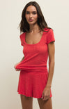 Woman wearing a red outfit against a plain background