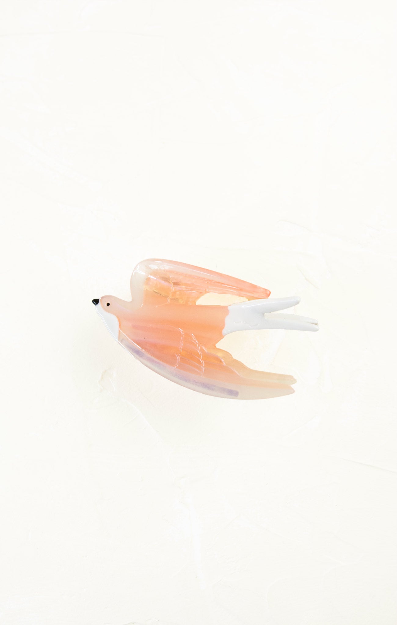 Glass figurine of a bird with orange and white feathers on a white background