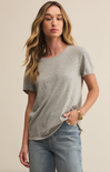 A woman wearing a white short-sleeved crew neck t-shirt with a regular fit, made from a brushed slub jersey fabric.