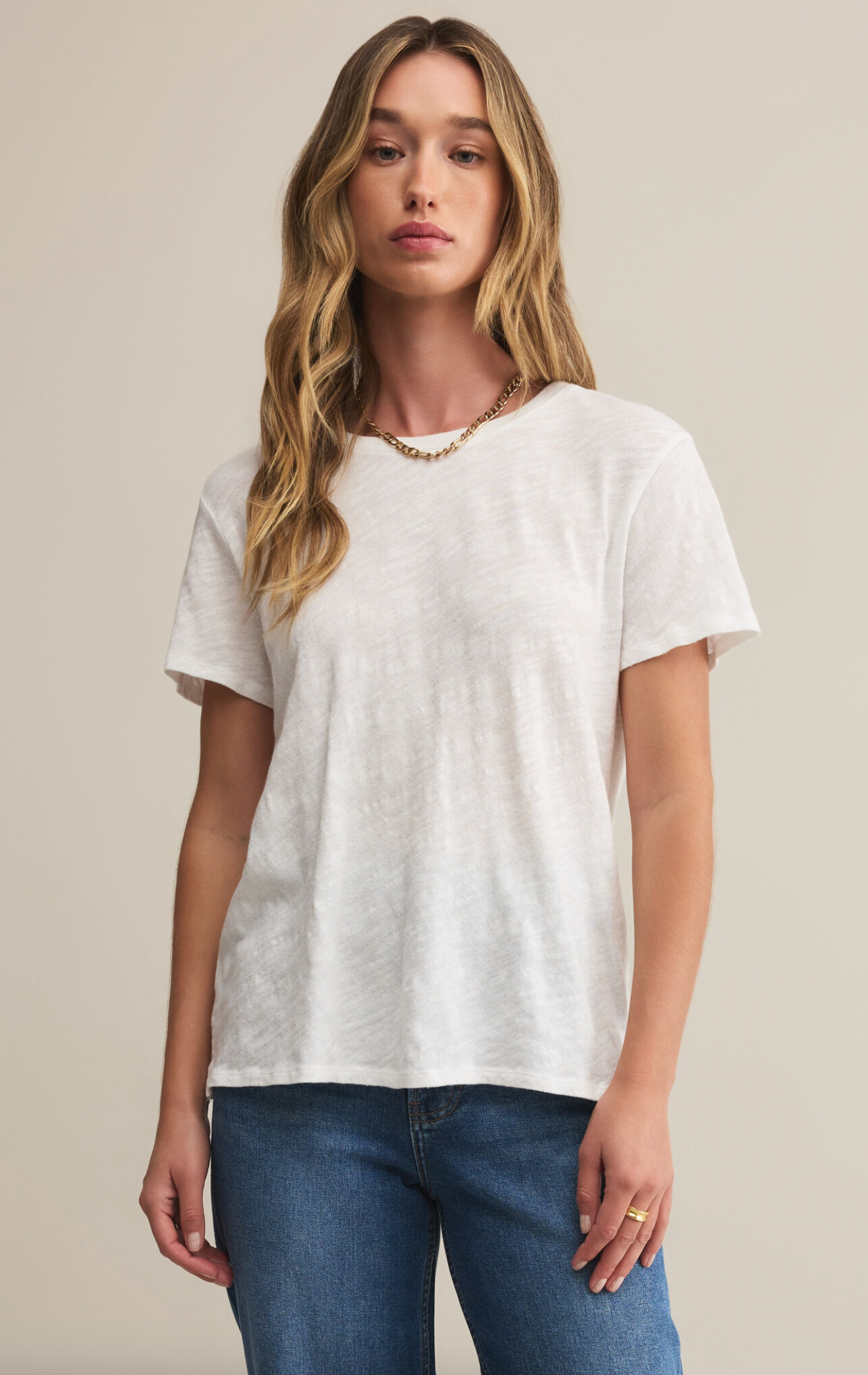 A woman wearing a white short-sleeved crew neck t-shirt with a regular fit, made from a brushed slub jersey fabric.