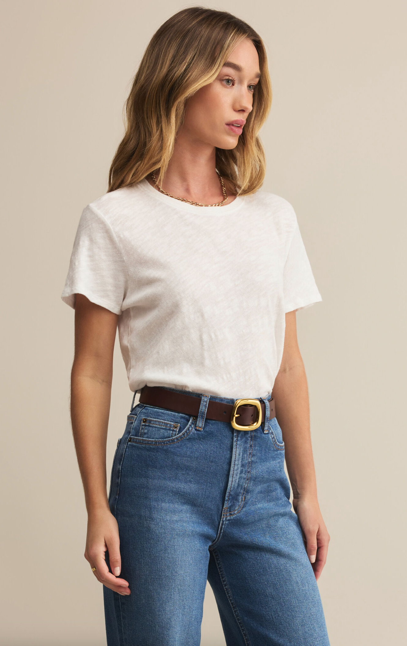 A woman wearing a white short-sleeved crew neck t-shirt with a regular fit, made from a brushed slub jersey fabric.