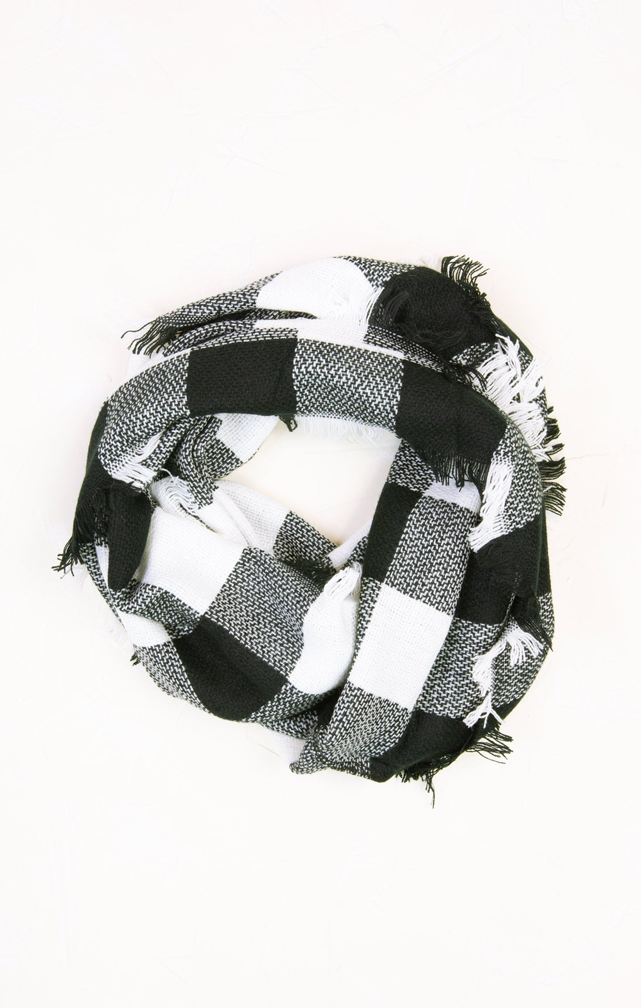 Black and white checkered scarf with fringes on a white background