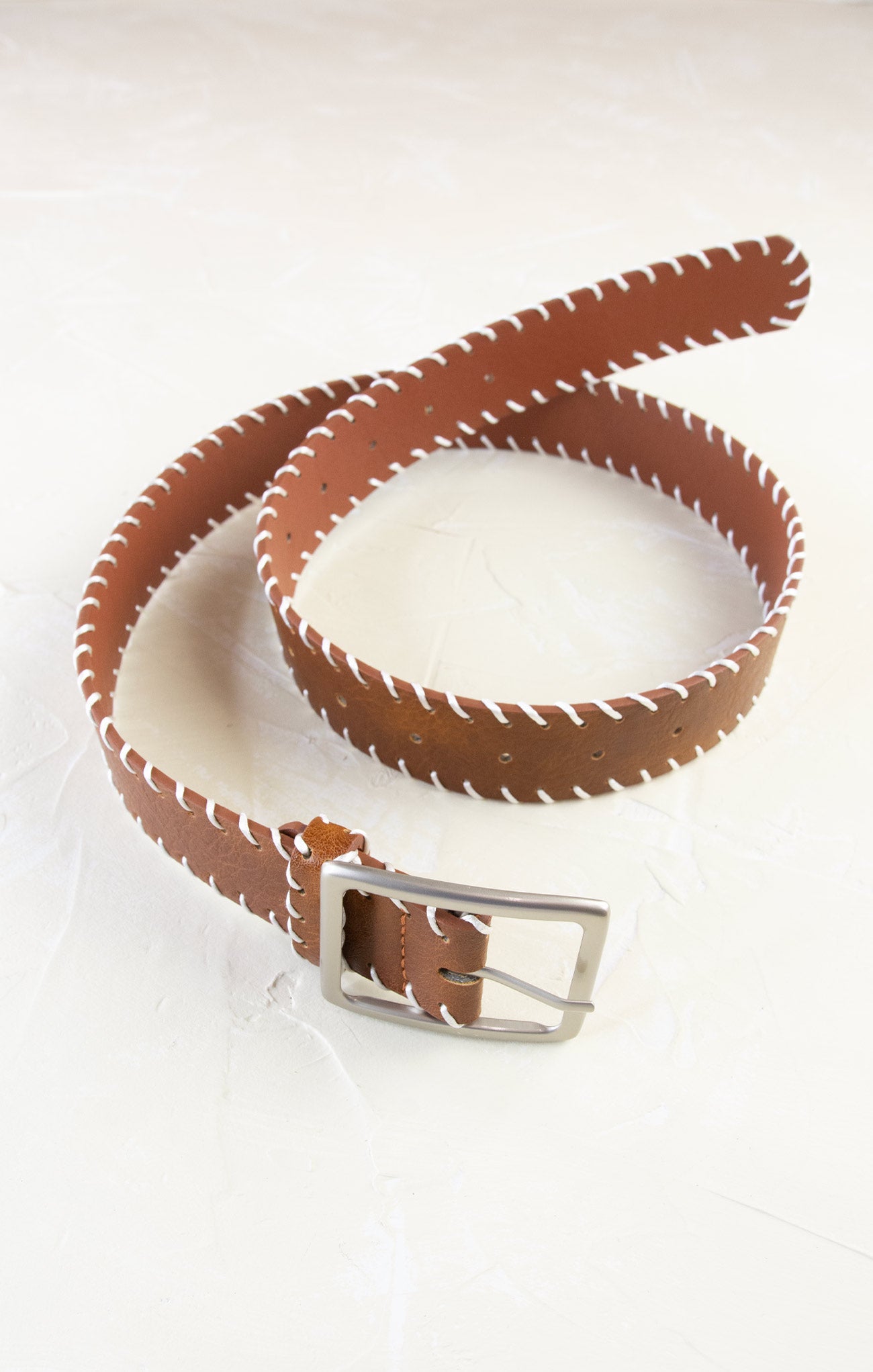 Brown leather belt with a silver buckle on a white background
